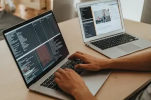 Programmer typing code on laptop